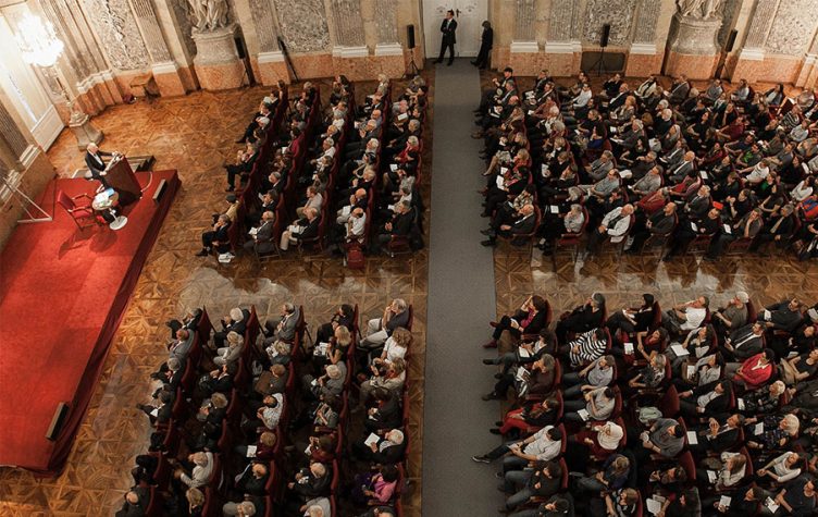 People listinening to a speach in the festival room.